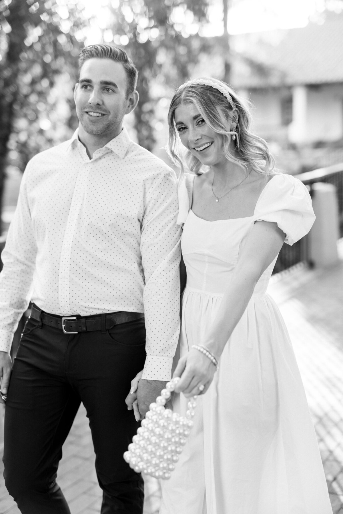 Timeless black and white engagement portrait—holding hands, sharing smiles, and radiating classic romance.