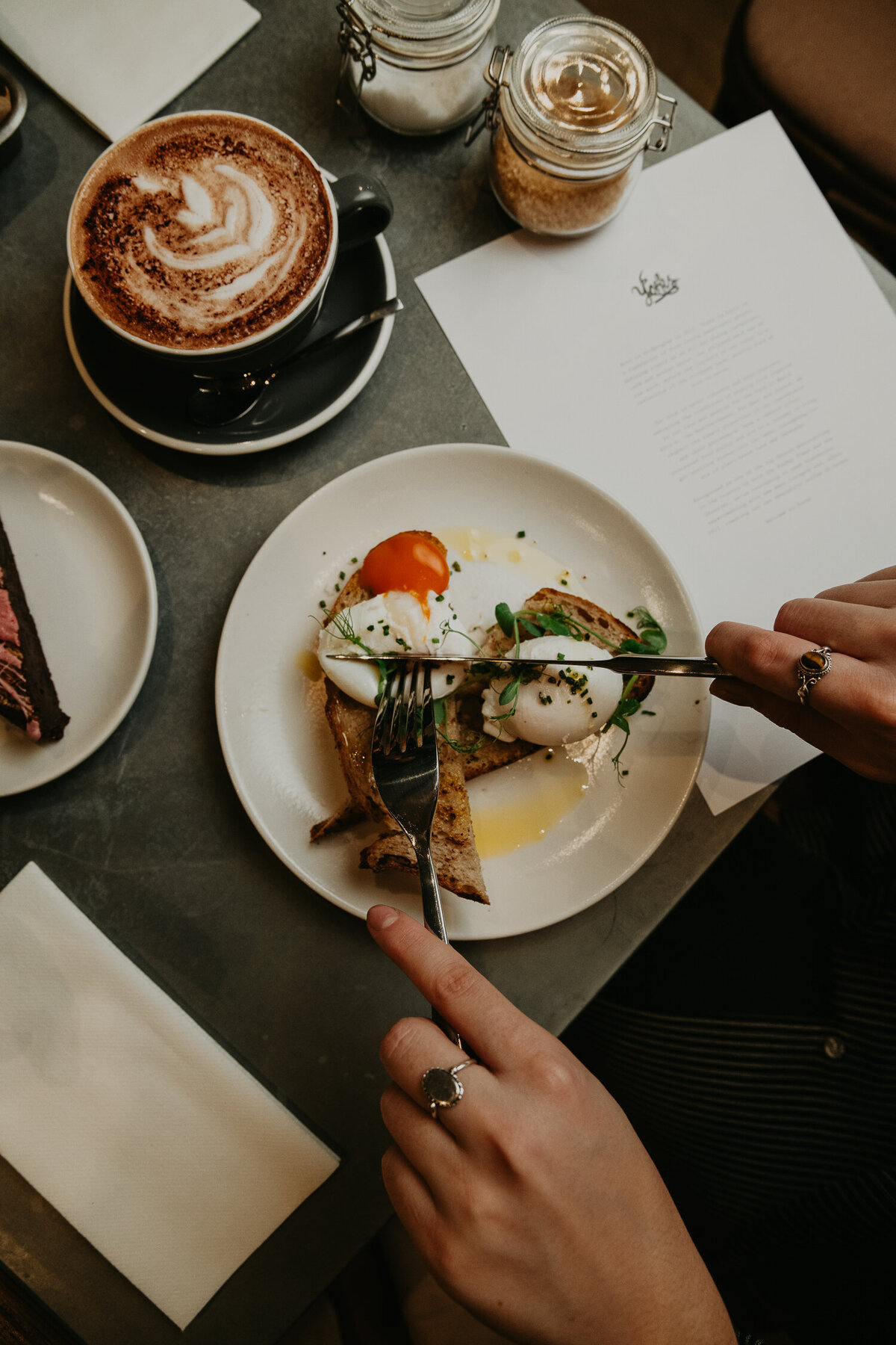 eggs Benedict being cut on a plate.