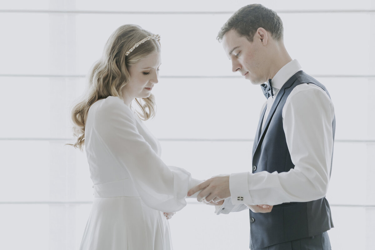 the groom fixing the bride's sleeves