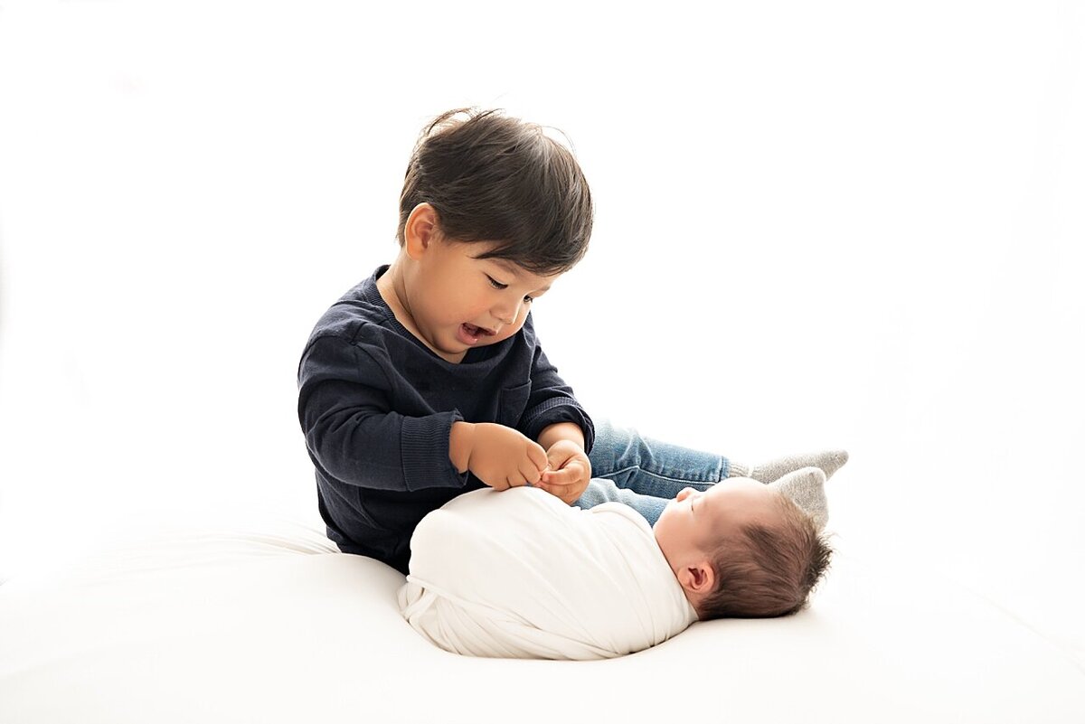 toddler with newborn sibling photo