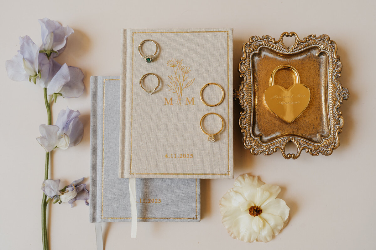 Wedding and engagement rings laying on top of vow books 