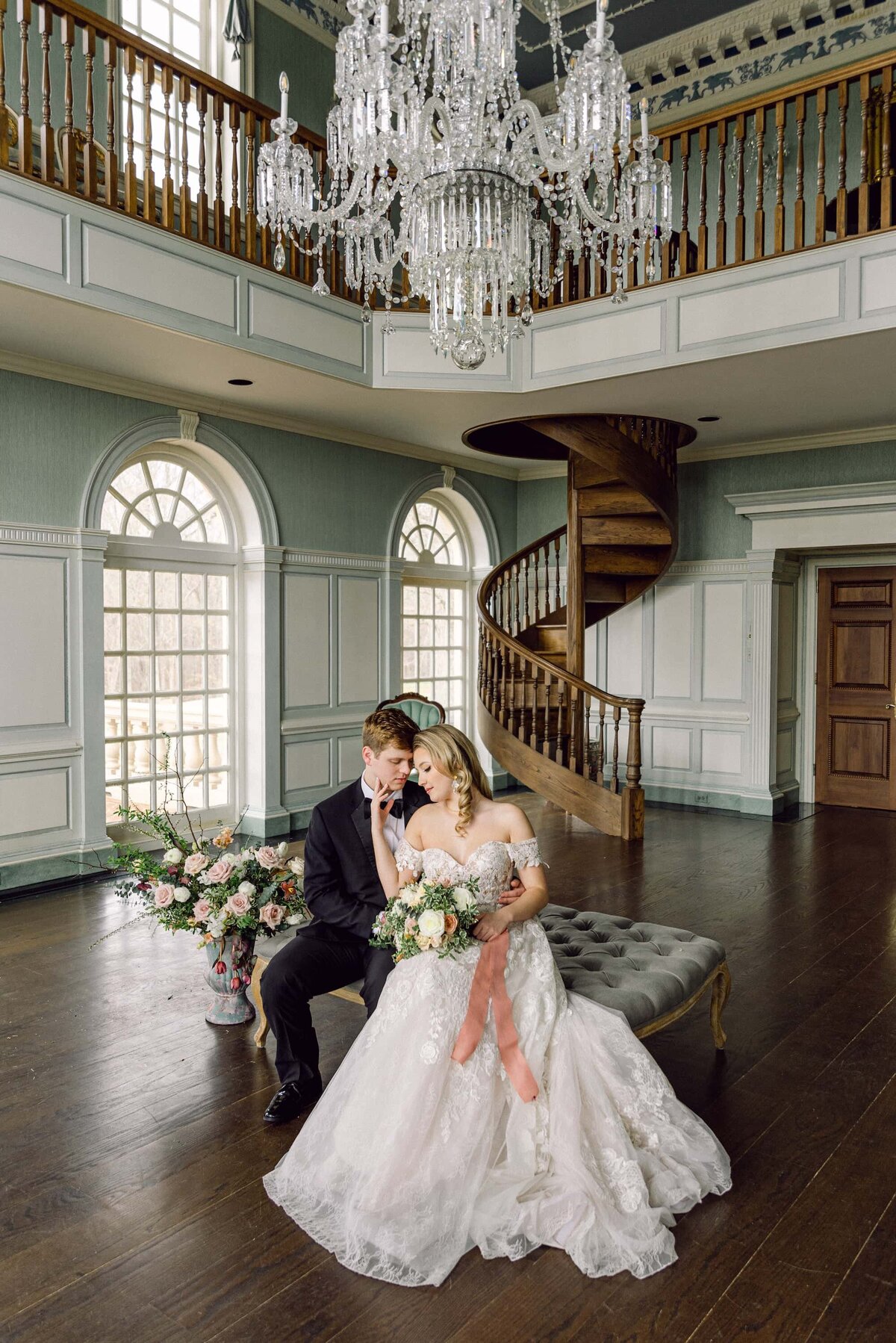 Bride and groom under chandelier at Estate at River Run