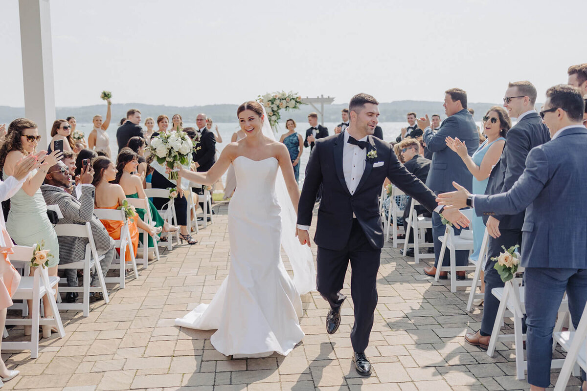 Bride and groom walking back down aisle after wedding ceremony at Canandaigua Country Club, NY