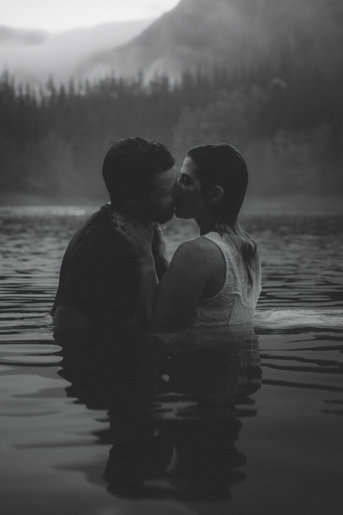 Engaged couple kissing in a lake in the Canadian Rockies