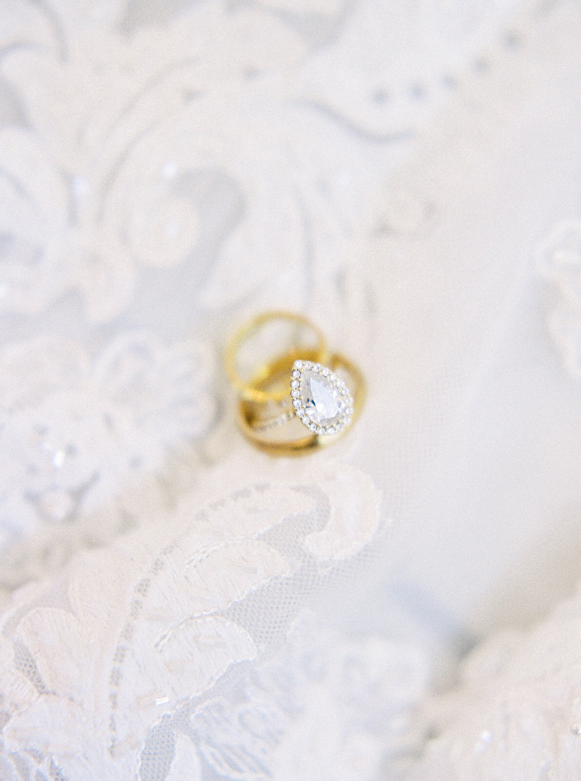 wedding rings on top of lace with the diamond sparkling