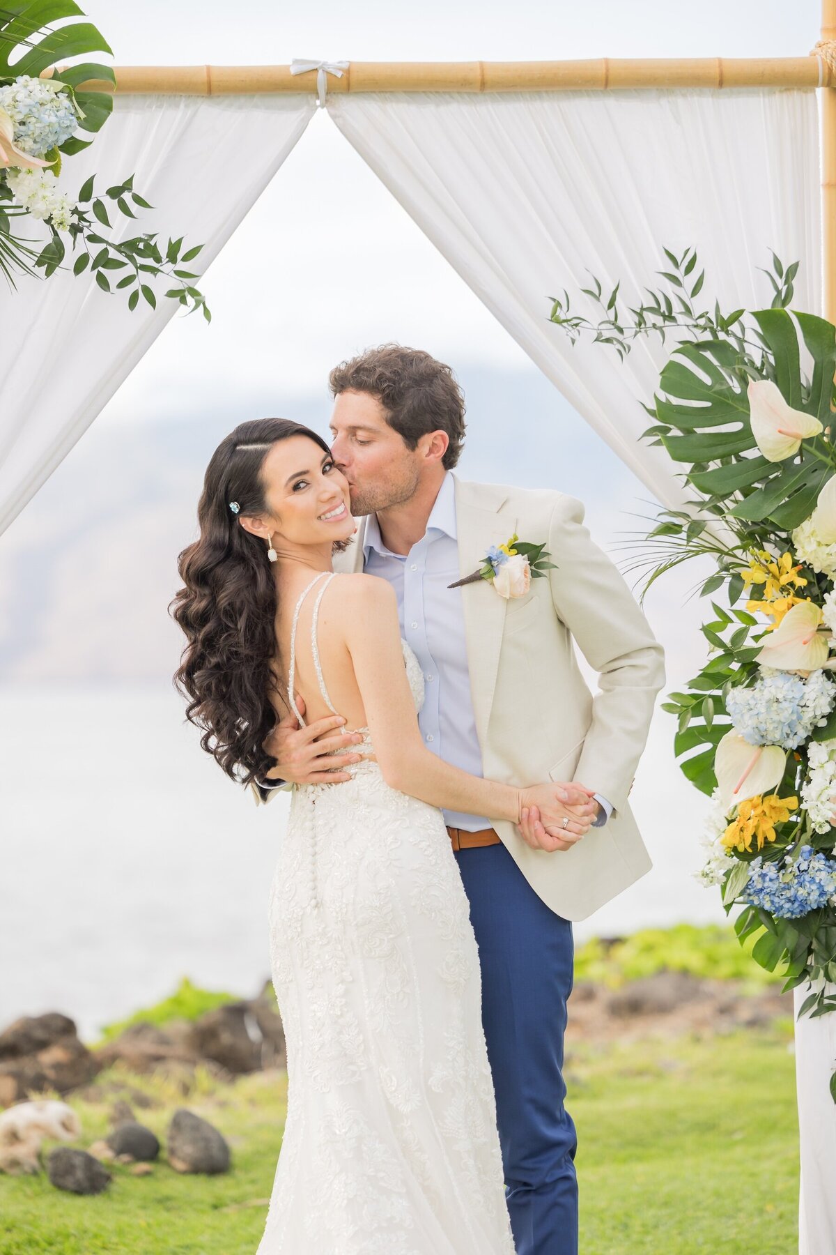 Hawaii wedding couple under bamboo arch during wedding