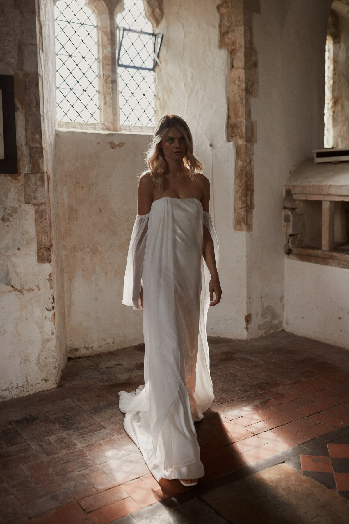 Detachable sleeves silk wedding dress by Luna Bea on bride in church