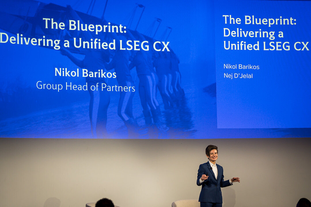 Corporate event photo of speaker presenting in front of wide conference audience new york.