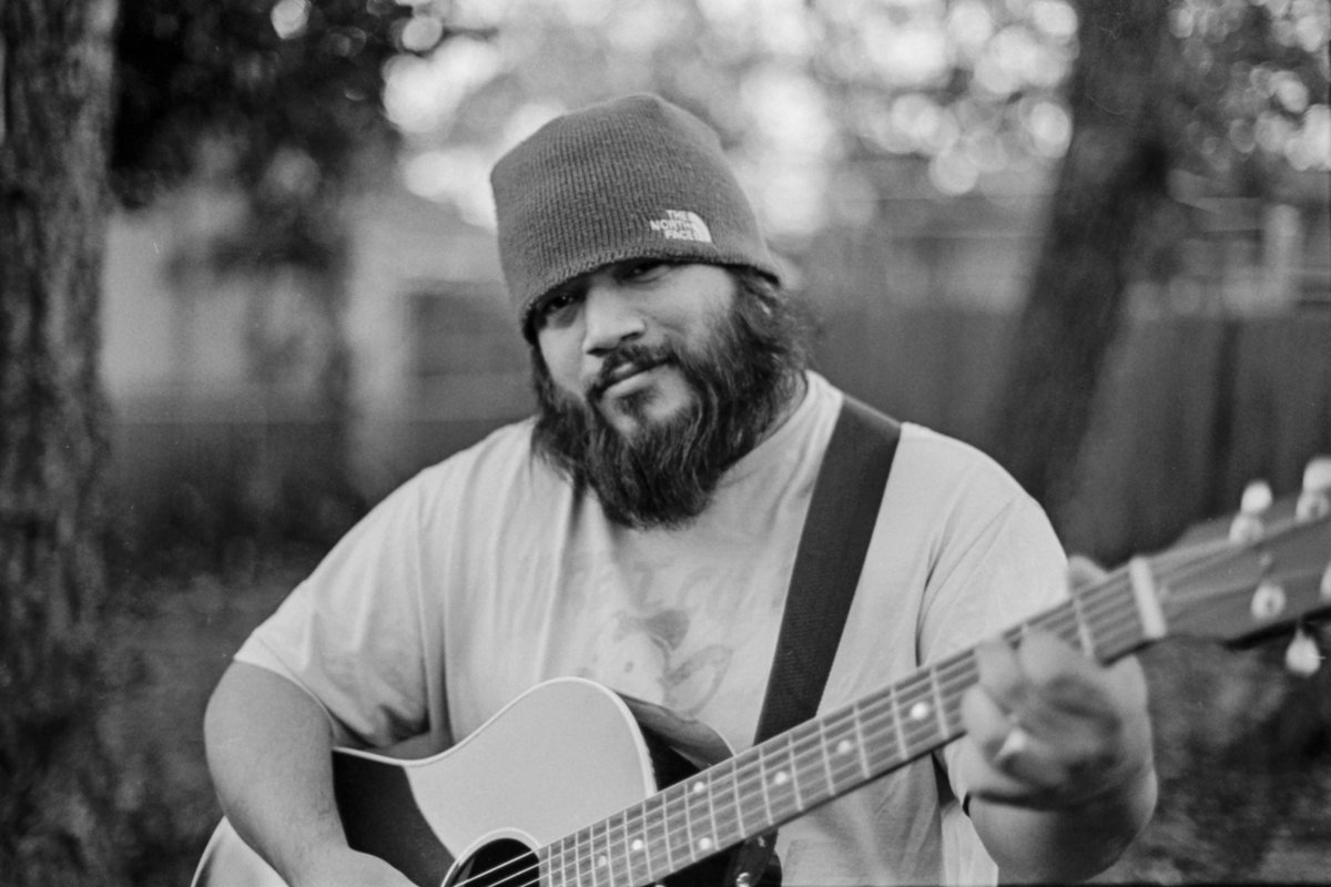 San Antonio Photographer David Castillo wearing North Face beanie and playing Gibson J45 acoustic guitar