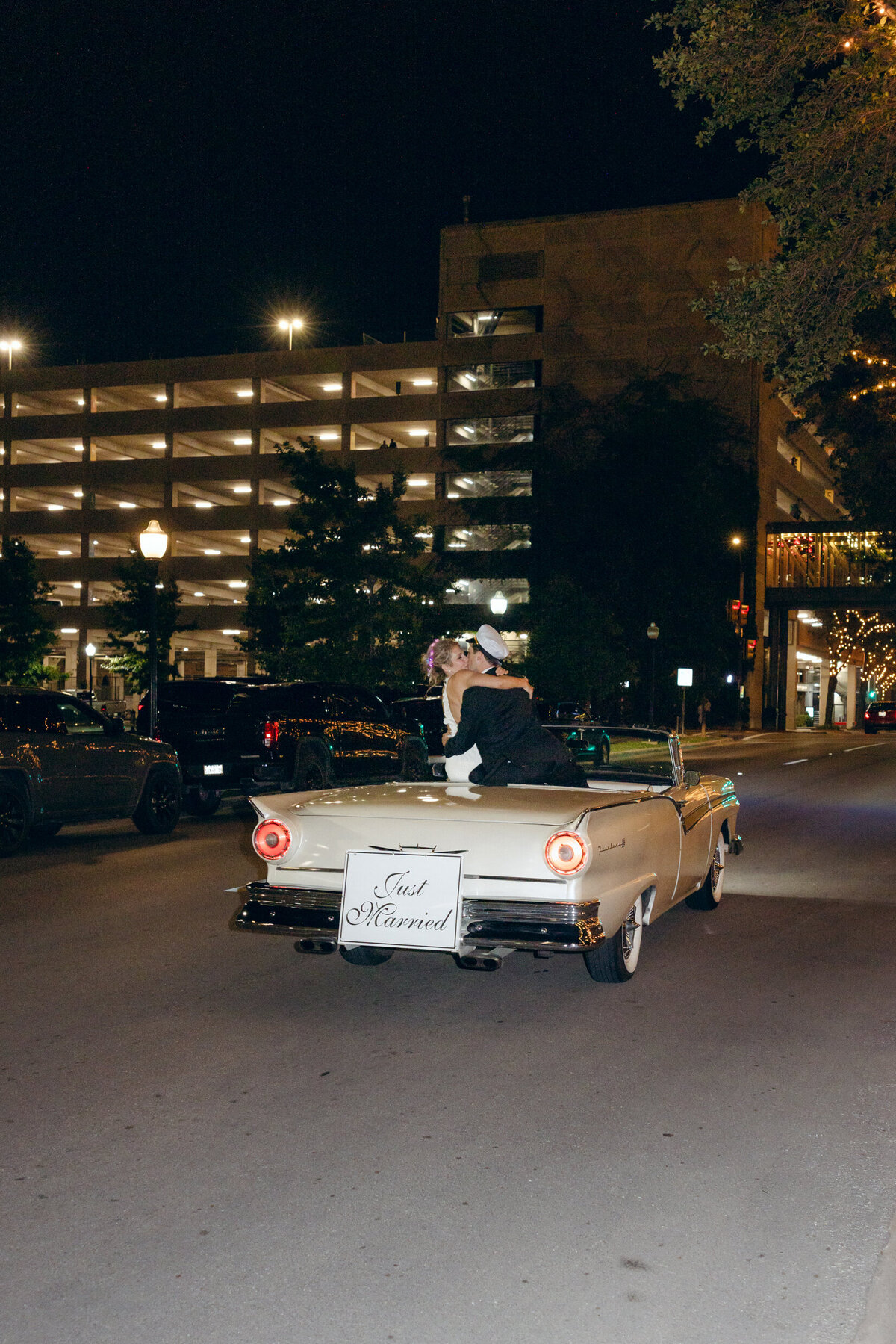 A wedding photo of the bride and groom in their getaway car in Forth Worth Texas