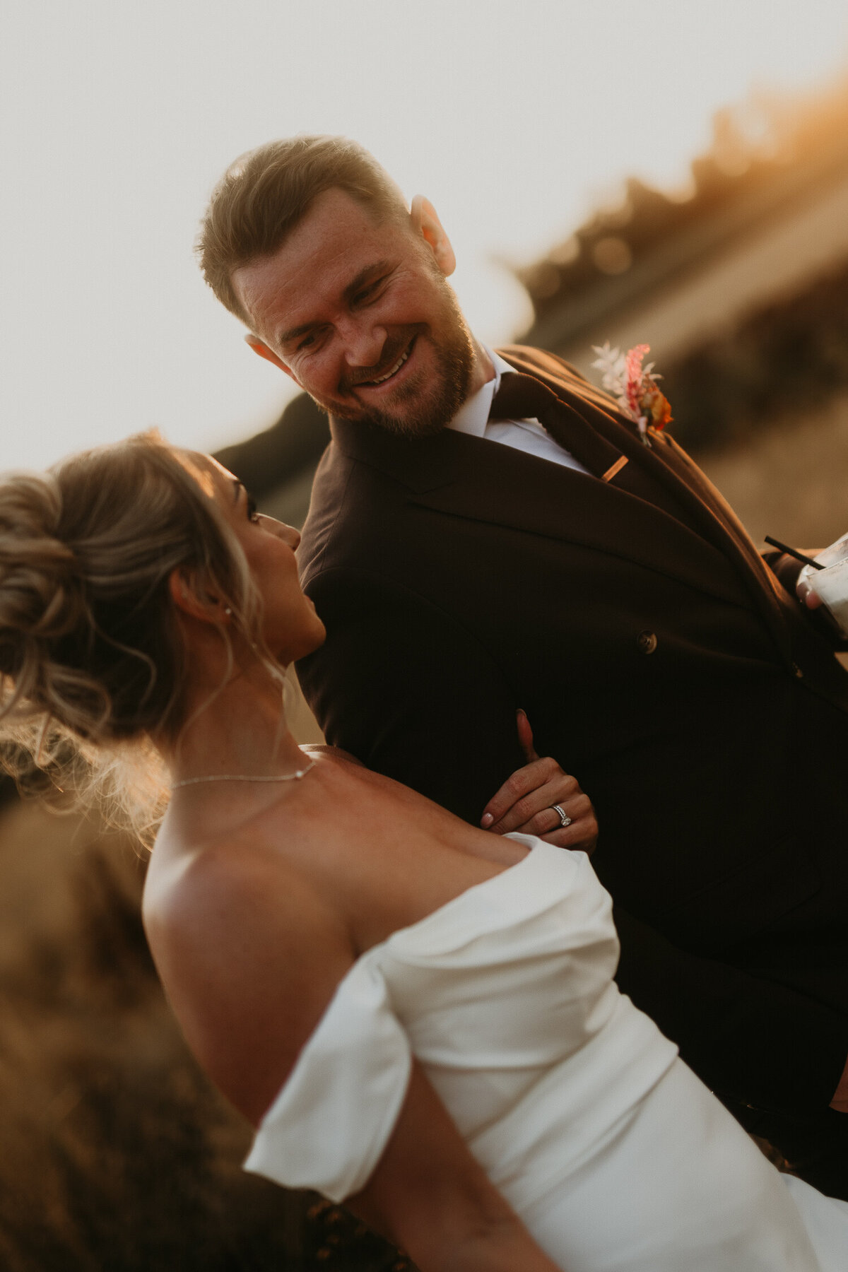 Bride and groom in the fields at Lapstone Barn during golden hour. 