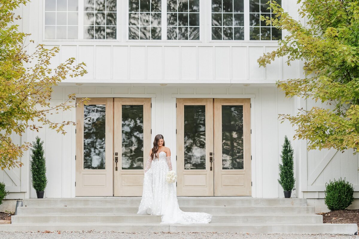 An Arkansas wedding photography image of a bride walking down some steps behind her venue