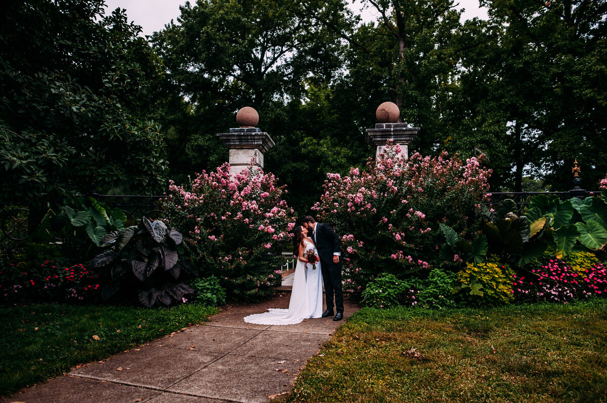 bride and groom at the front gates in tower grove park