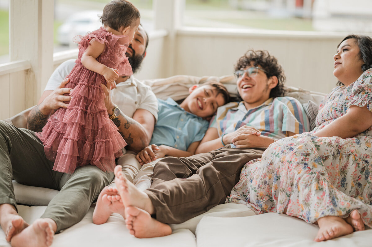 A family cuddles and laughs together.