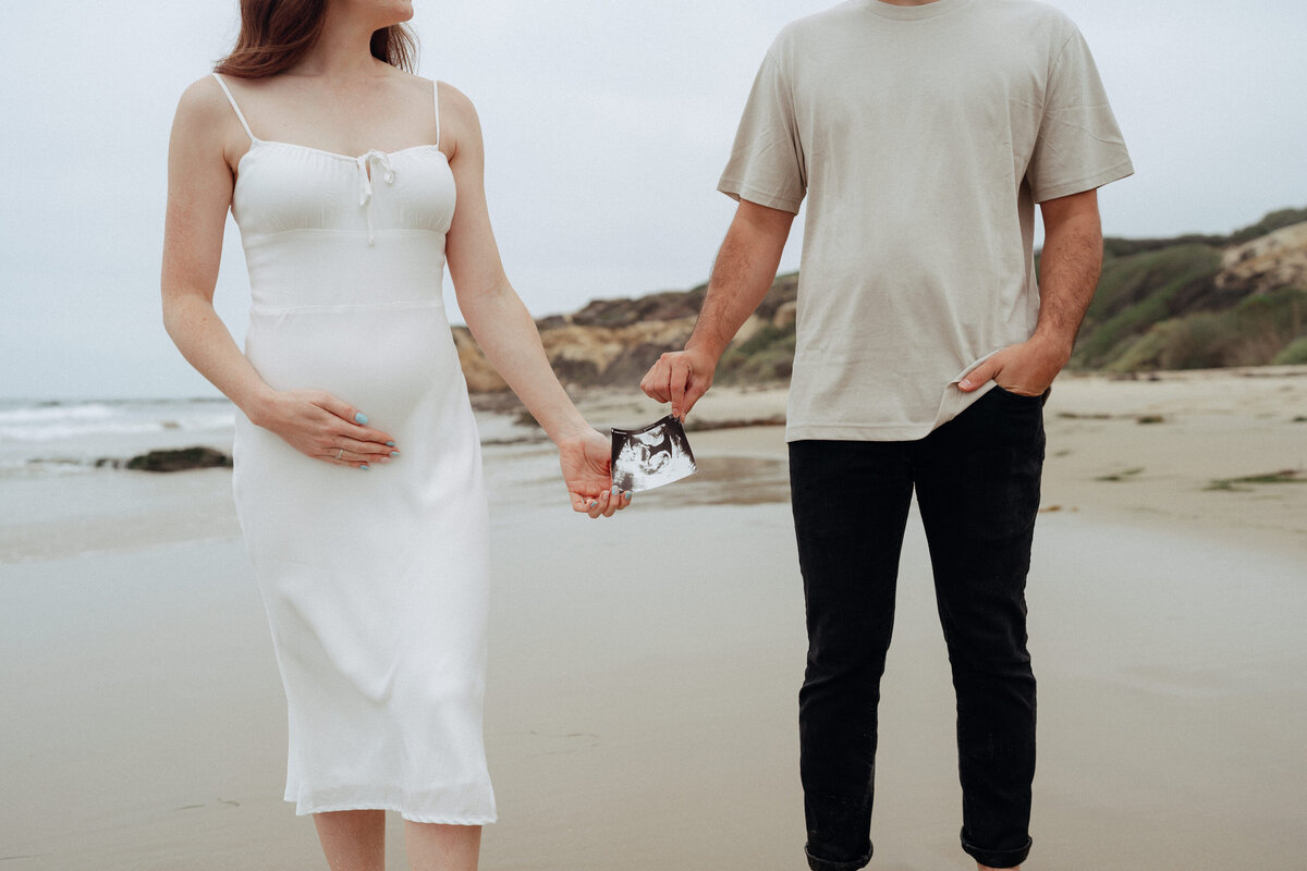 couple shoot for maternity session during golden hour Oregon coast beach wedding/elopement - photographed by The Storytellers