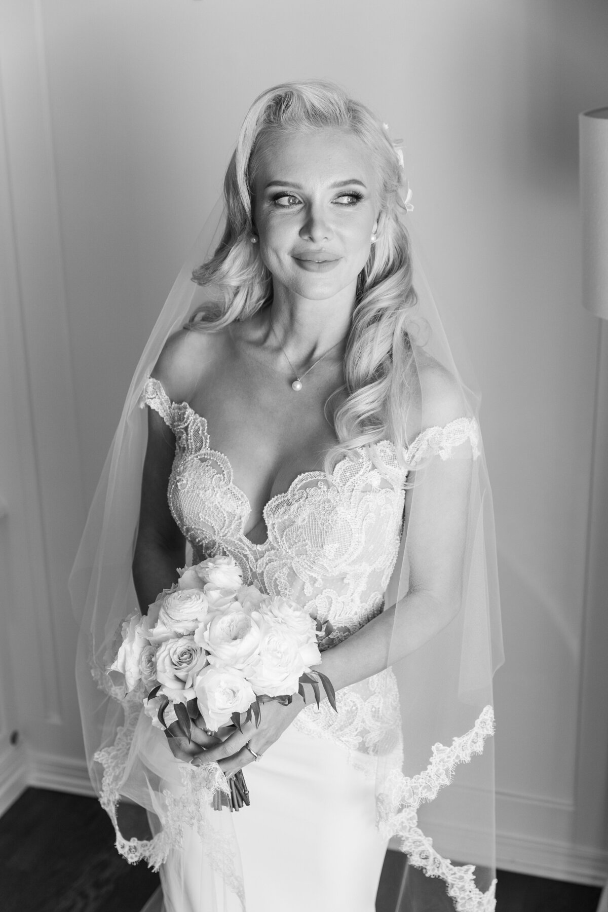 A black and white photo of a bride holding a bouquet of flowers