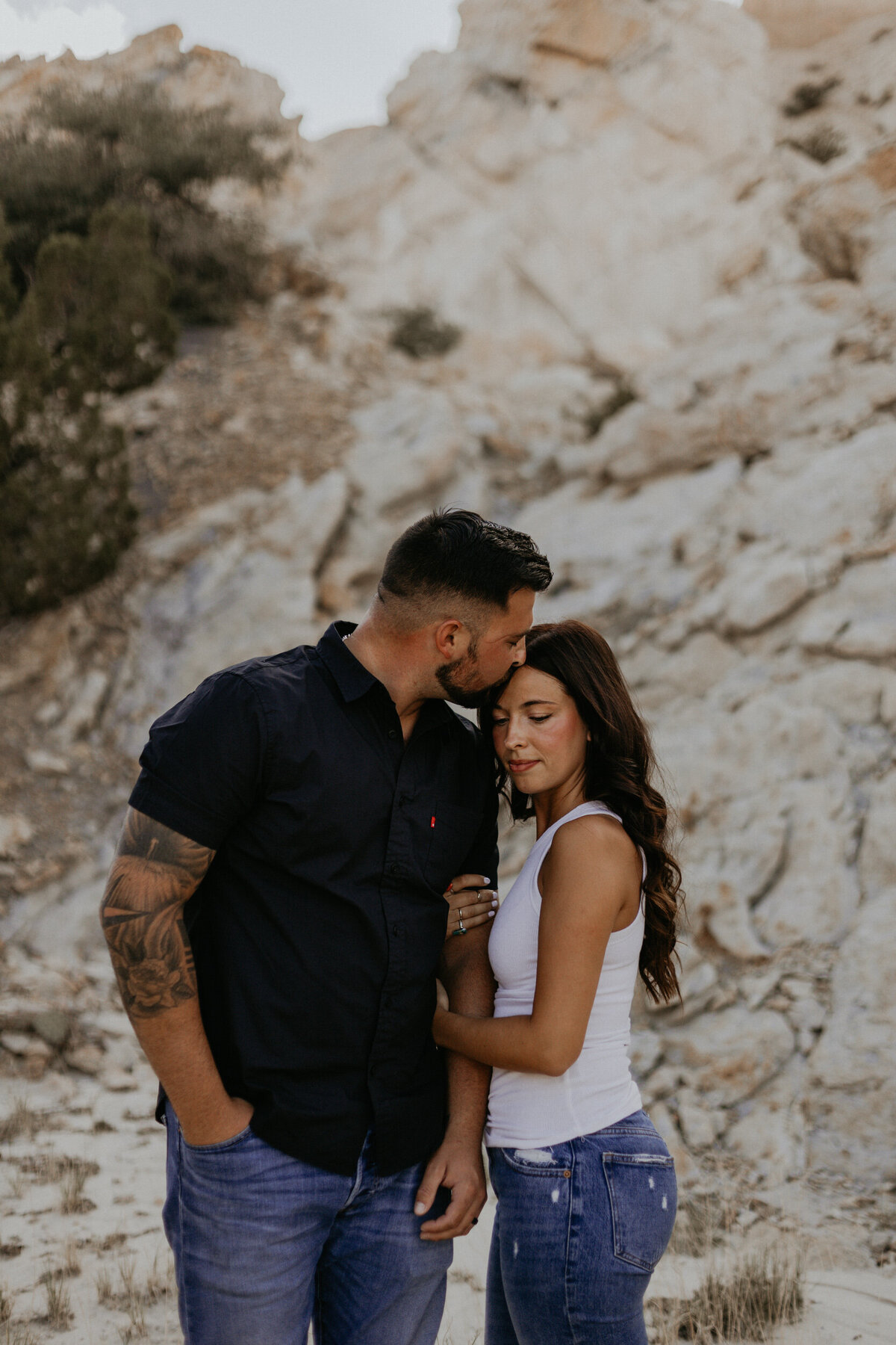 woman holding her fiancés arm in the desert