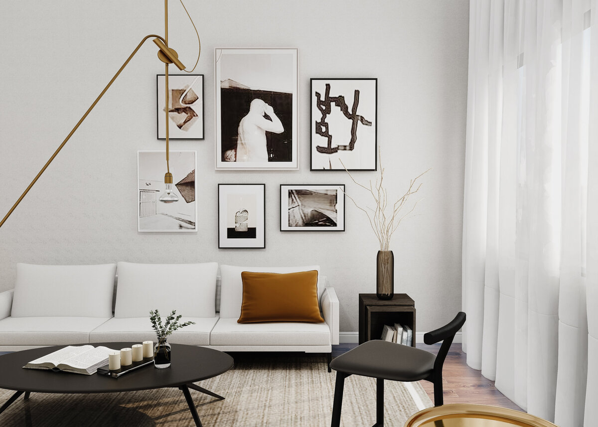 A monochrome modern lounge is styled with a gallery wall and a white sofa and a burnt orange accent cushion.