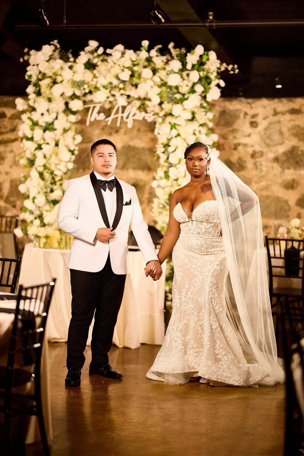 Bride and groom holding hands while taking a photo