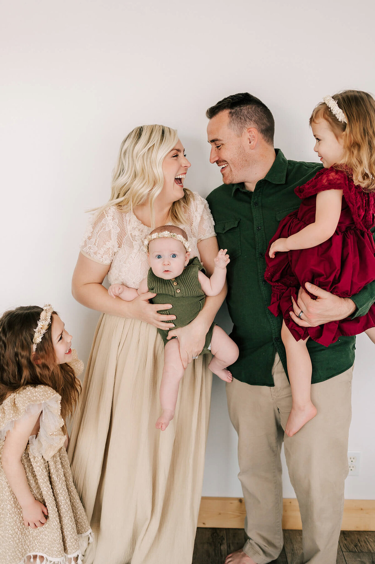 family photo of parents laughing holding kids in photography studio in Branson