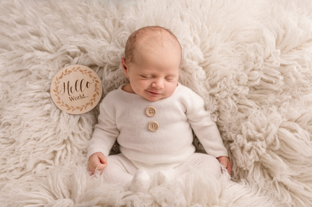 Newborn baby in white sleepsuit