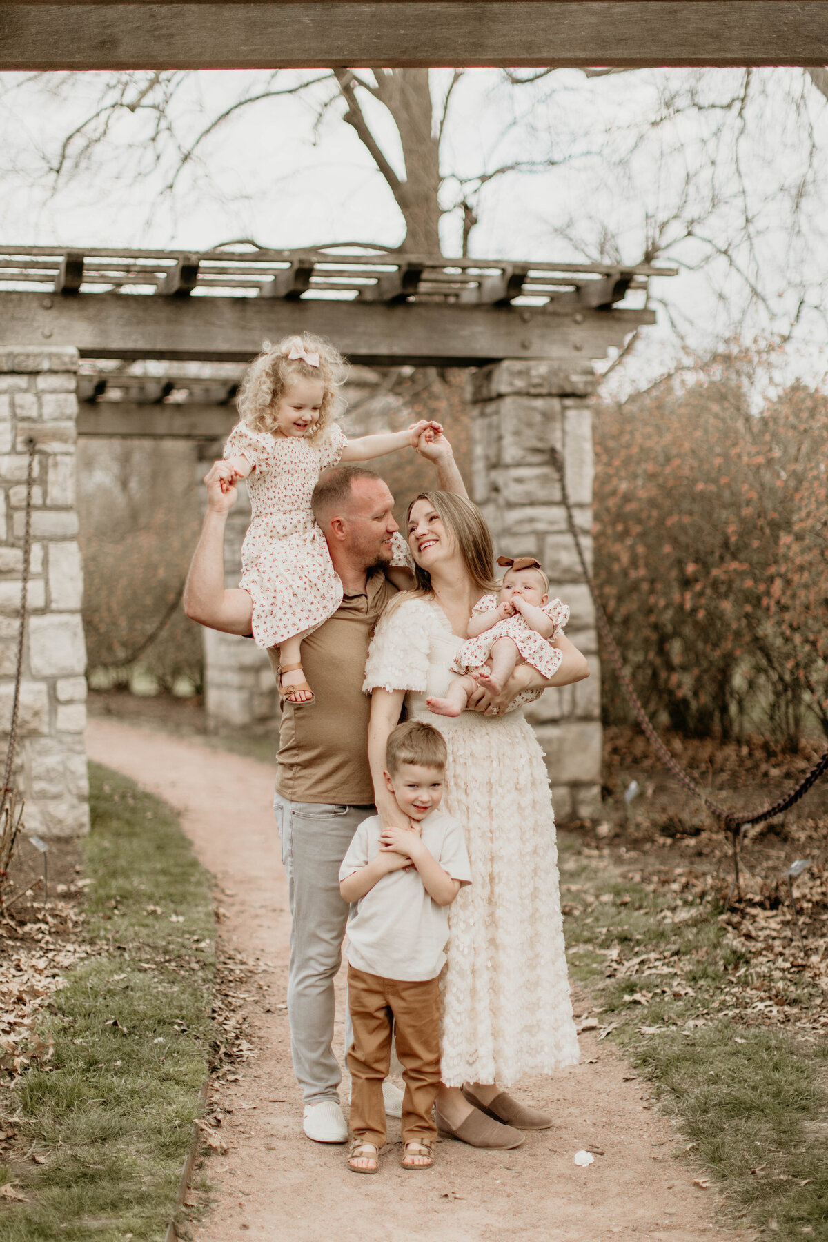 Family of 5 in close embrace, smiling at one another. 