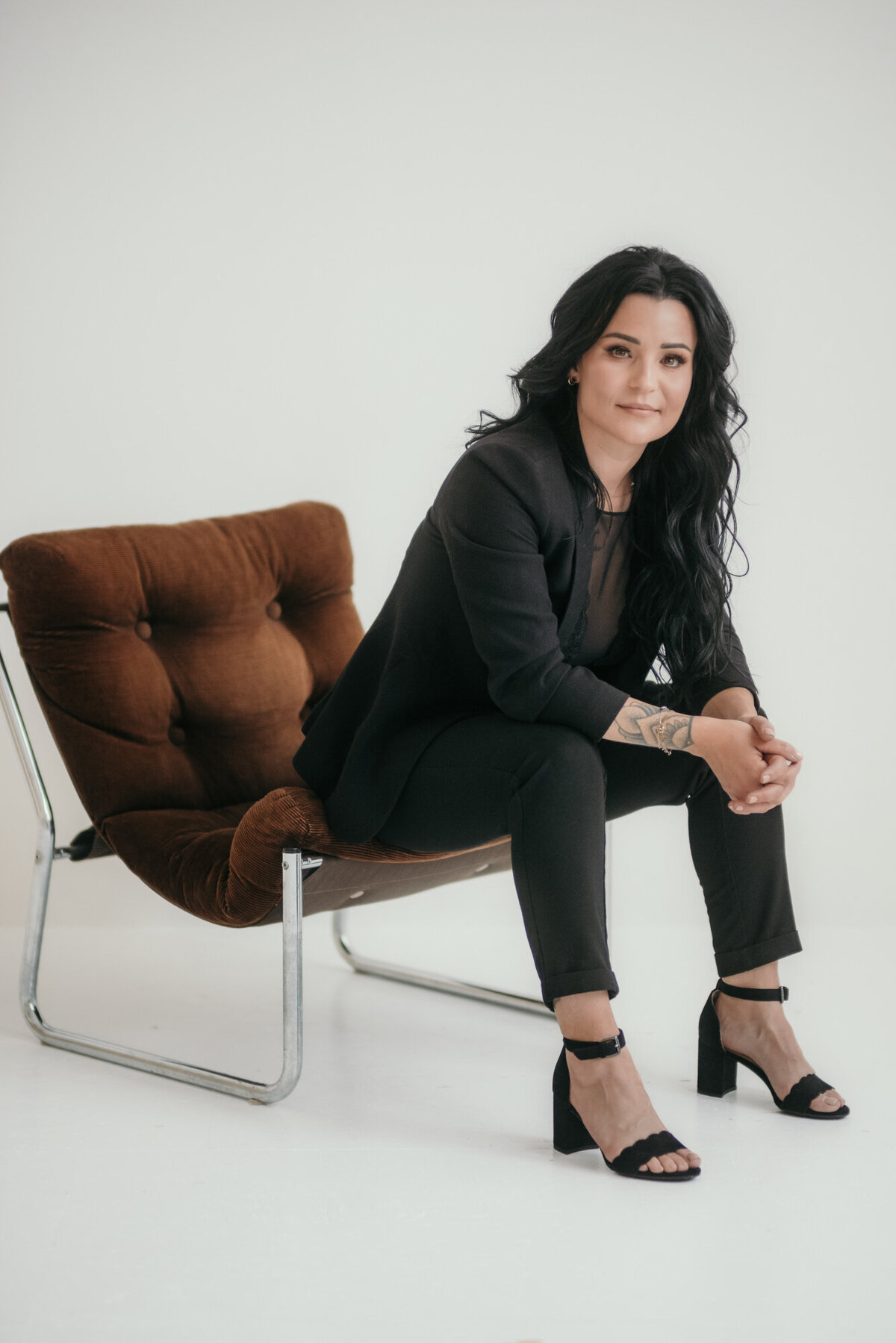 Businesswoman sits on a leather chair.