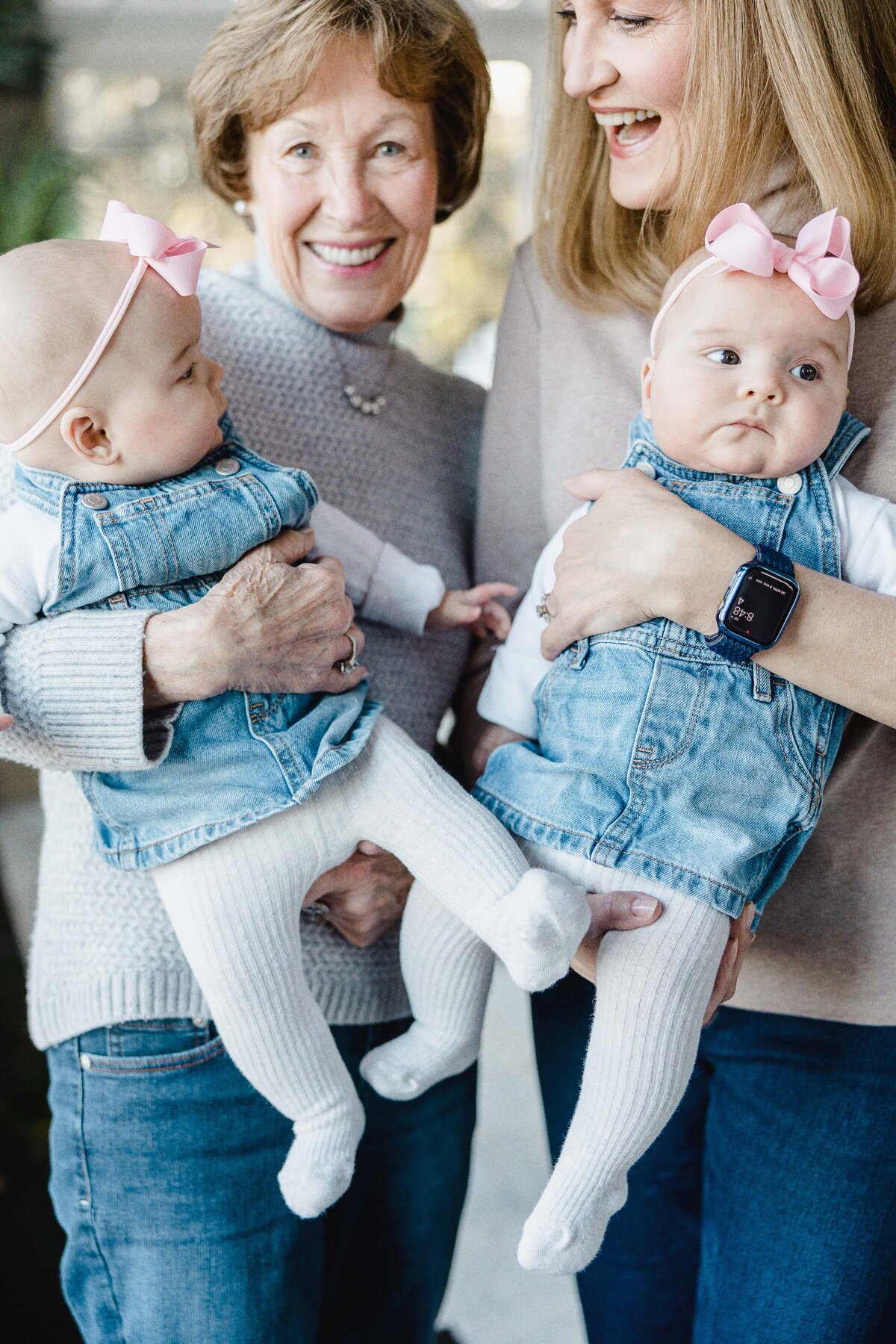 two grandmothers holding twin babies