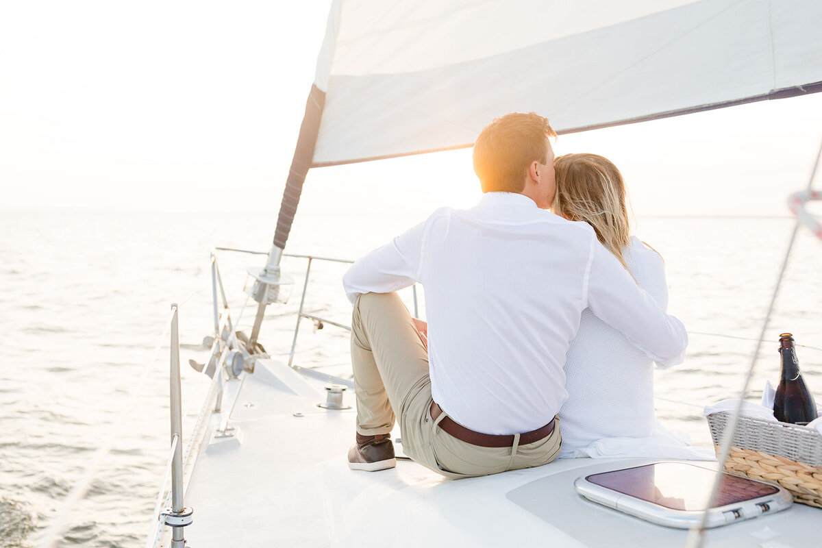Couple after proposal on sailboat at sunset
