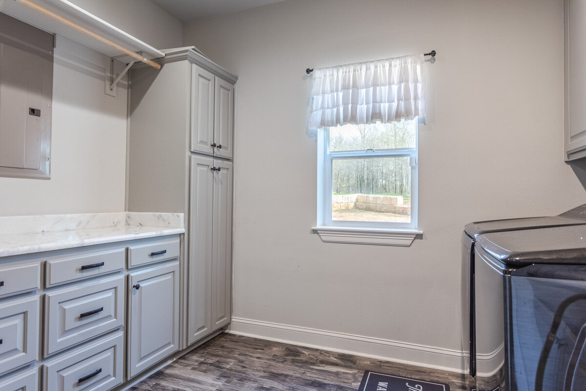 Laundry room with washer and dryer in this five-bedroom, 3-bathroom vacation rental house for up to 10 guests with free wifi, private parking, outdoor games and seating, and bbq grill on 2 acres of land near Waco, TX.
