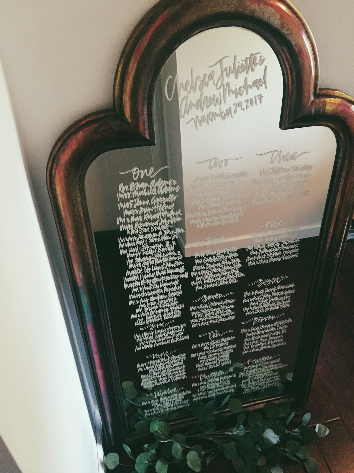 calligraphy seating chart on an antique mirror