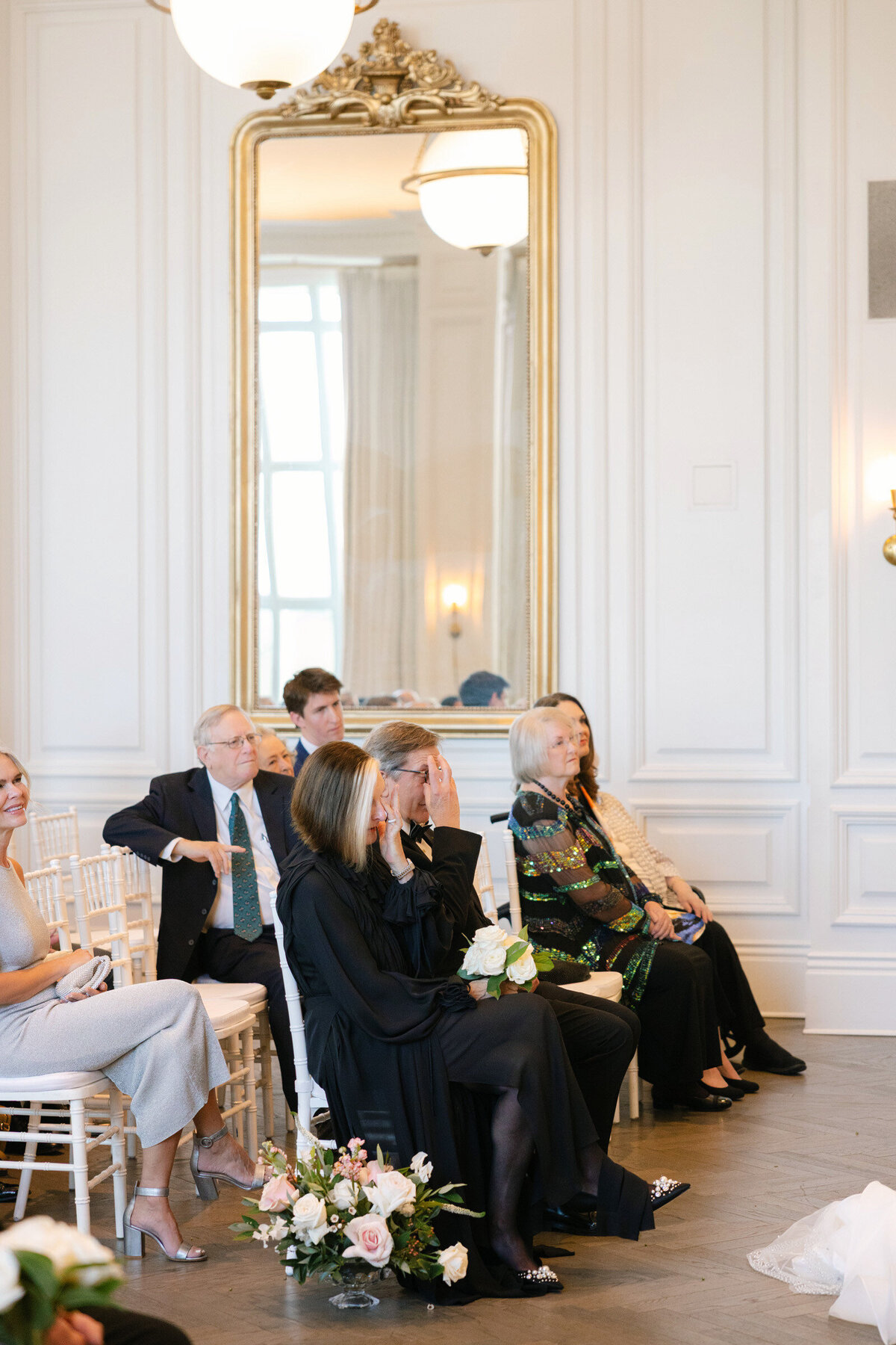 groom’s parents wiping away tears during the wedding ceremony in the Governor’s Room at The Adolphus in Dallas, capturing an emotional and heartfelt moment.