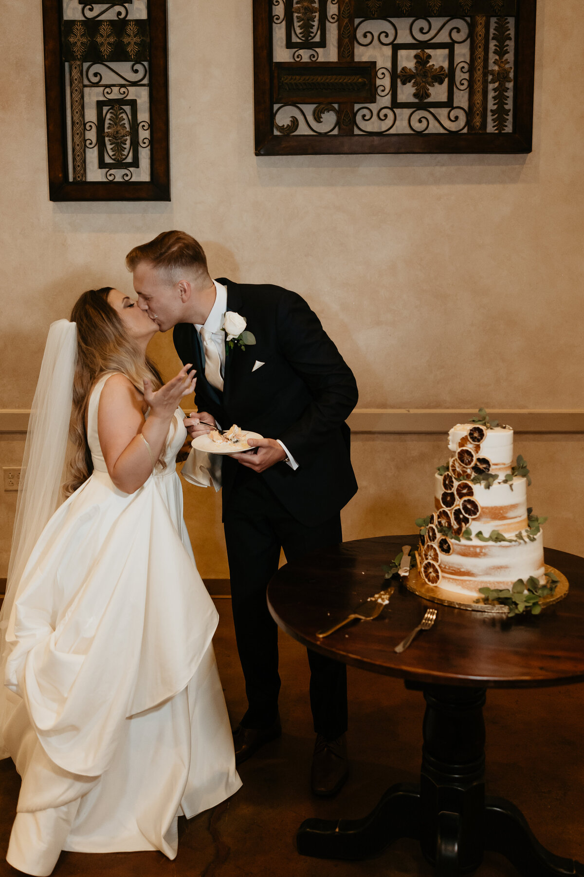 Bride and Groom kissing after cutting the cake at Luxury Italian Venue