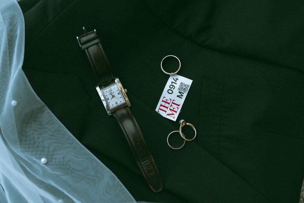 flat lay of watch, wedding rings, Met ticket, and veil shot by Elsie Goodman Photography | NYC Elopement Packages