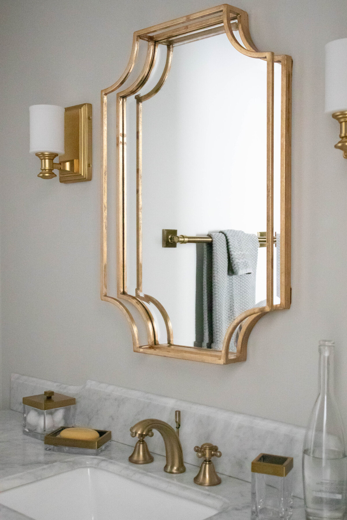 Elegant bathroom in Concord, NC, featuring a gold-framed mirror and classic white walls.