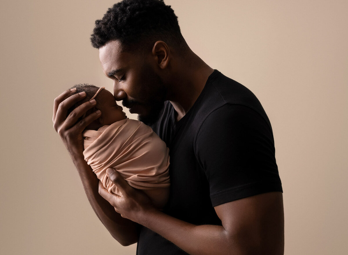 Father holding newborn baby brown wrap Austin professional family photographer