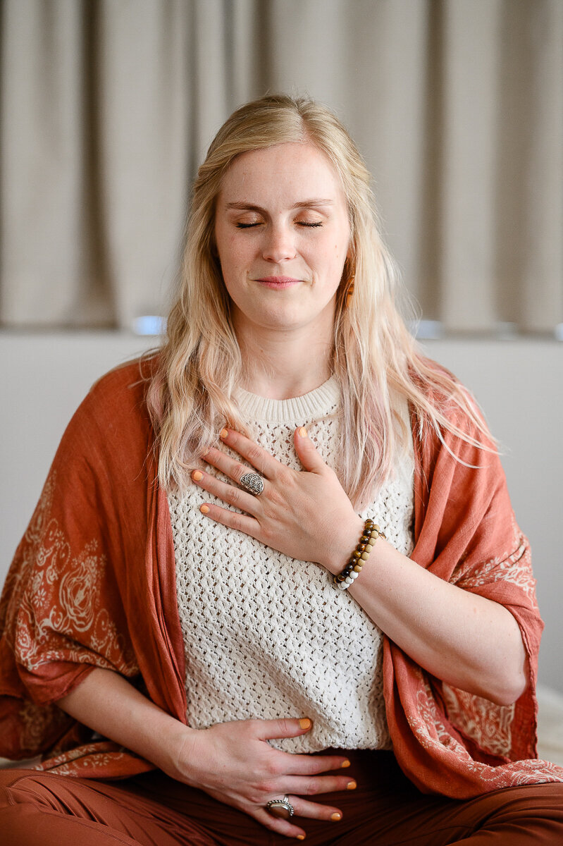 A branding photographer in Denver takes a photo of a woman meditating during her brand photos for her brand photo shoot.