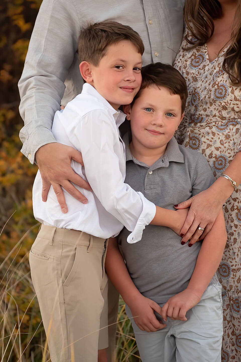 Two brothers pose with thier arms around each other at Wingaersheek beach.