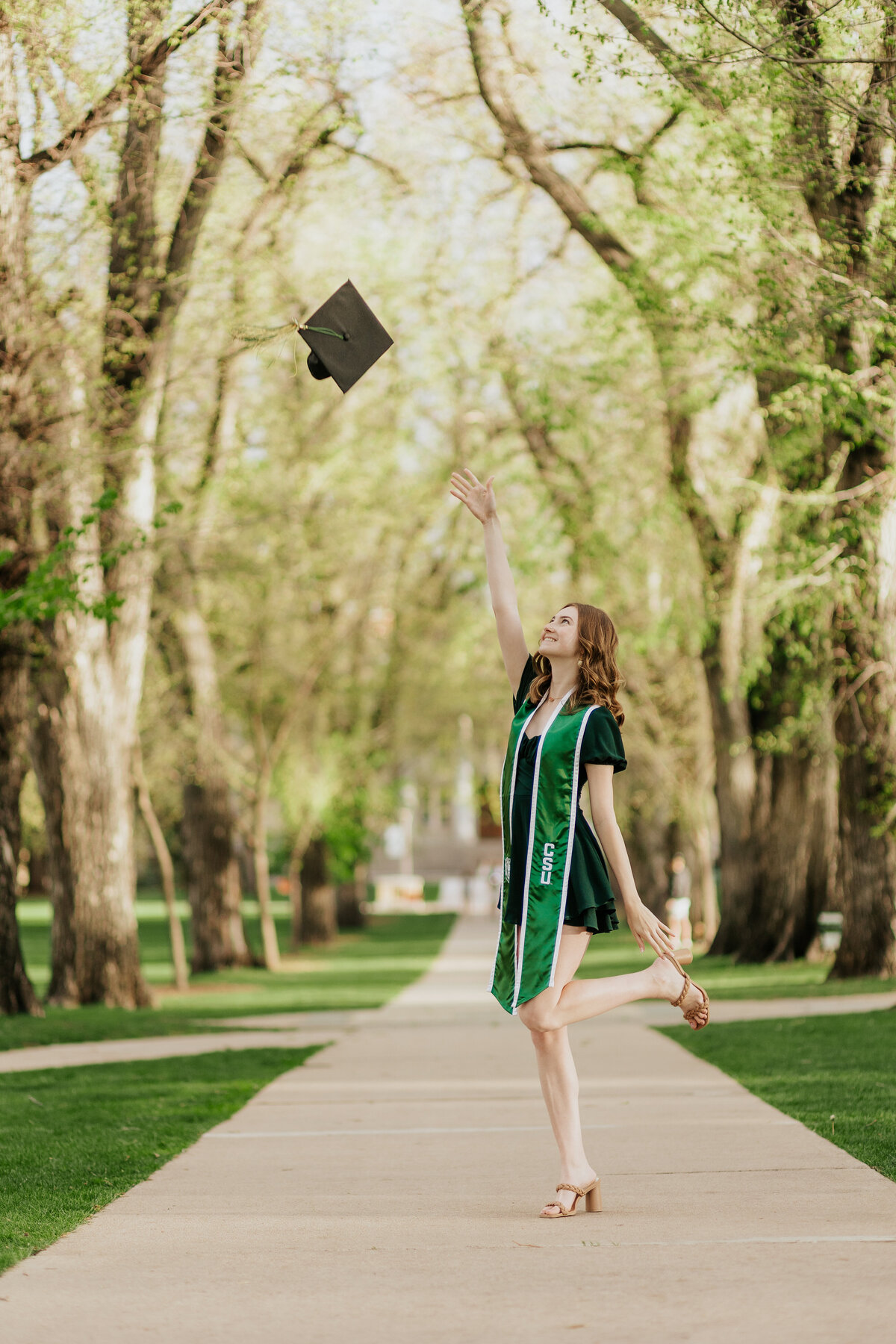 A Colorado State University graduate tosses her cap in the air, celebrating her graduation in Fort Collins, Colorado.