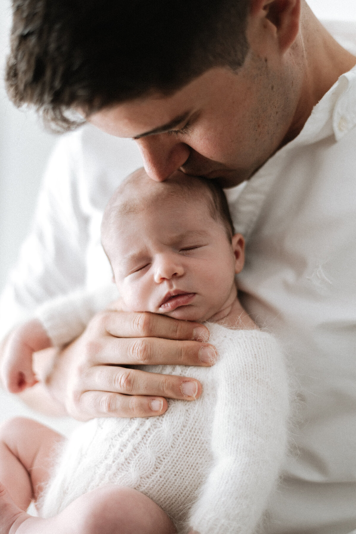 a father holding his newborn daughter in billingshurst at newborn photoshoot