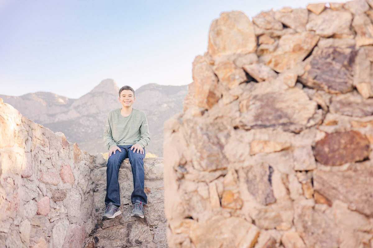 Teenage boy sitting on a rock wall for Erin Thompson Photography