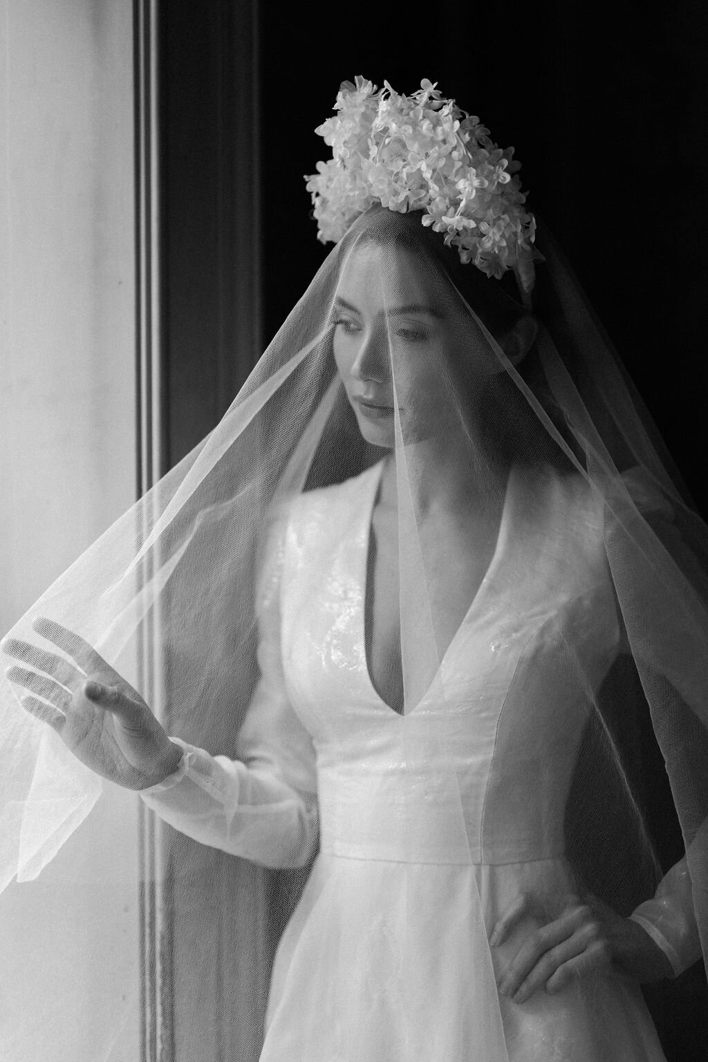 bride wearing wedding dress moving veil with her fingers
