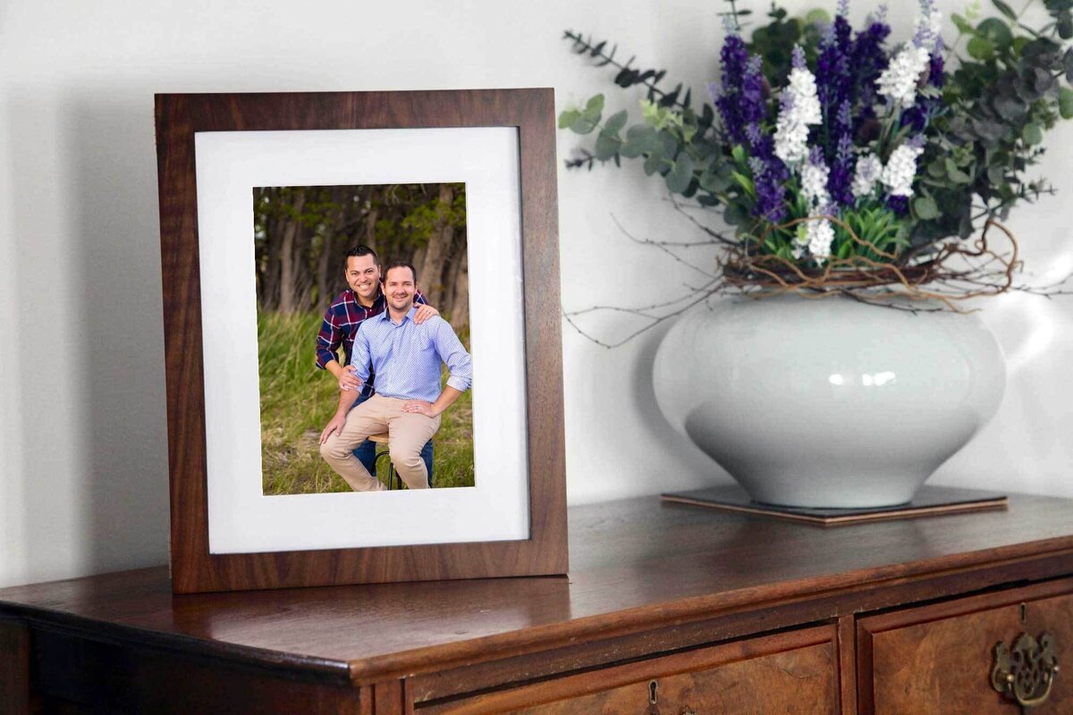 table with a framed  photograph of a couple  sitting on it