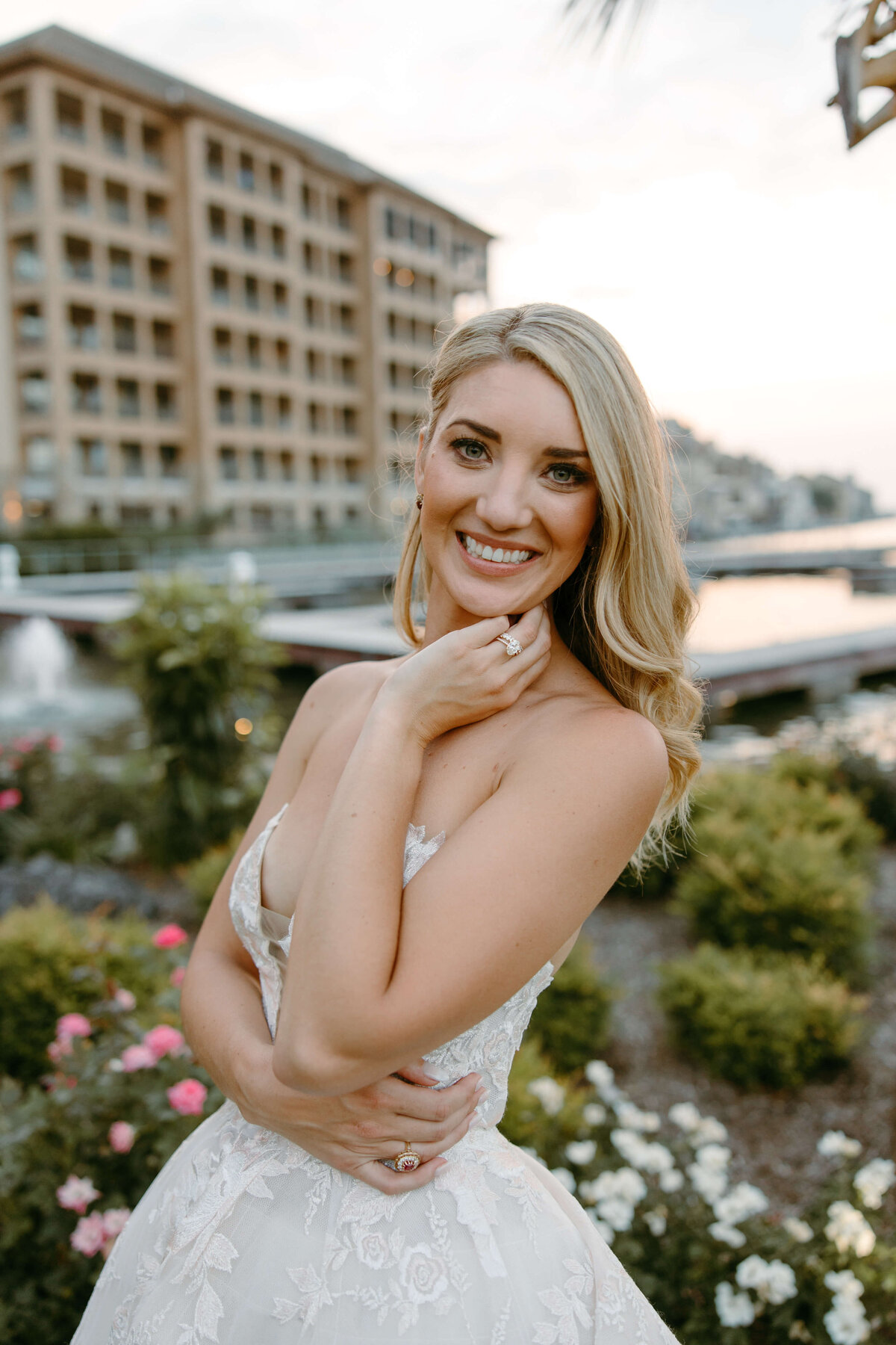Blonde bride smiling outdoors in elegant bridal makeup, photographed at sunset near Austin wedding venue.