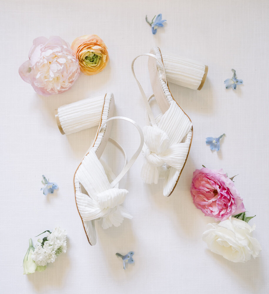 flat lay of bridal shoes with flowers