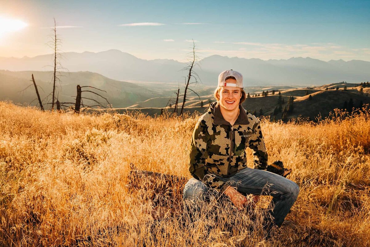 Montana senior photo male sitting in field at sunset, Hamilton, MT