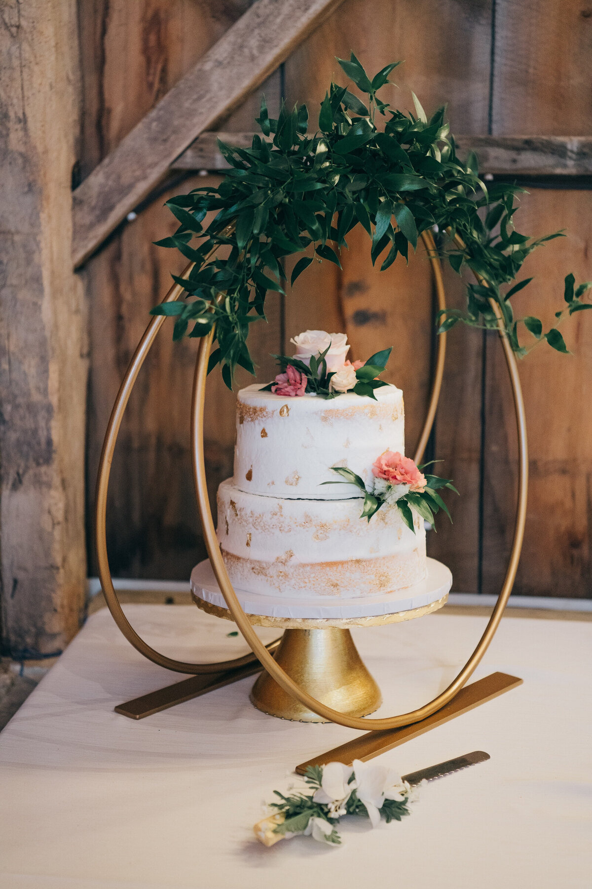 A simple, rustic white wedding cake with real flower accents