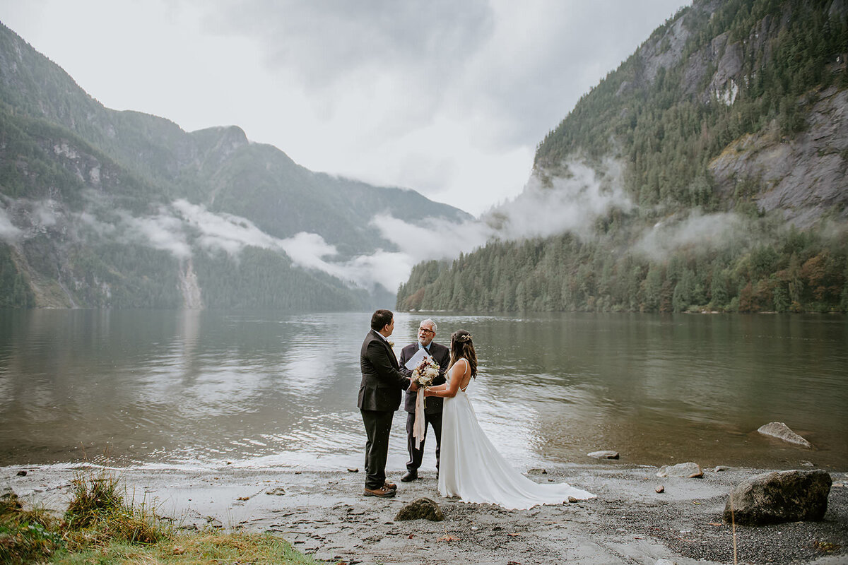 Couple standng against a mountain backdrop during their adventure elopement.