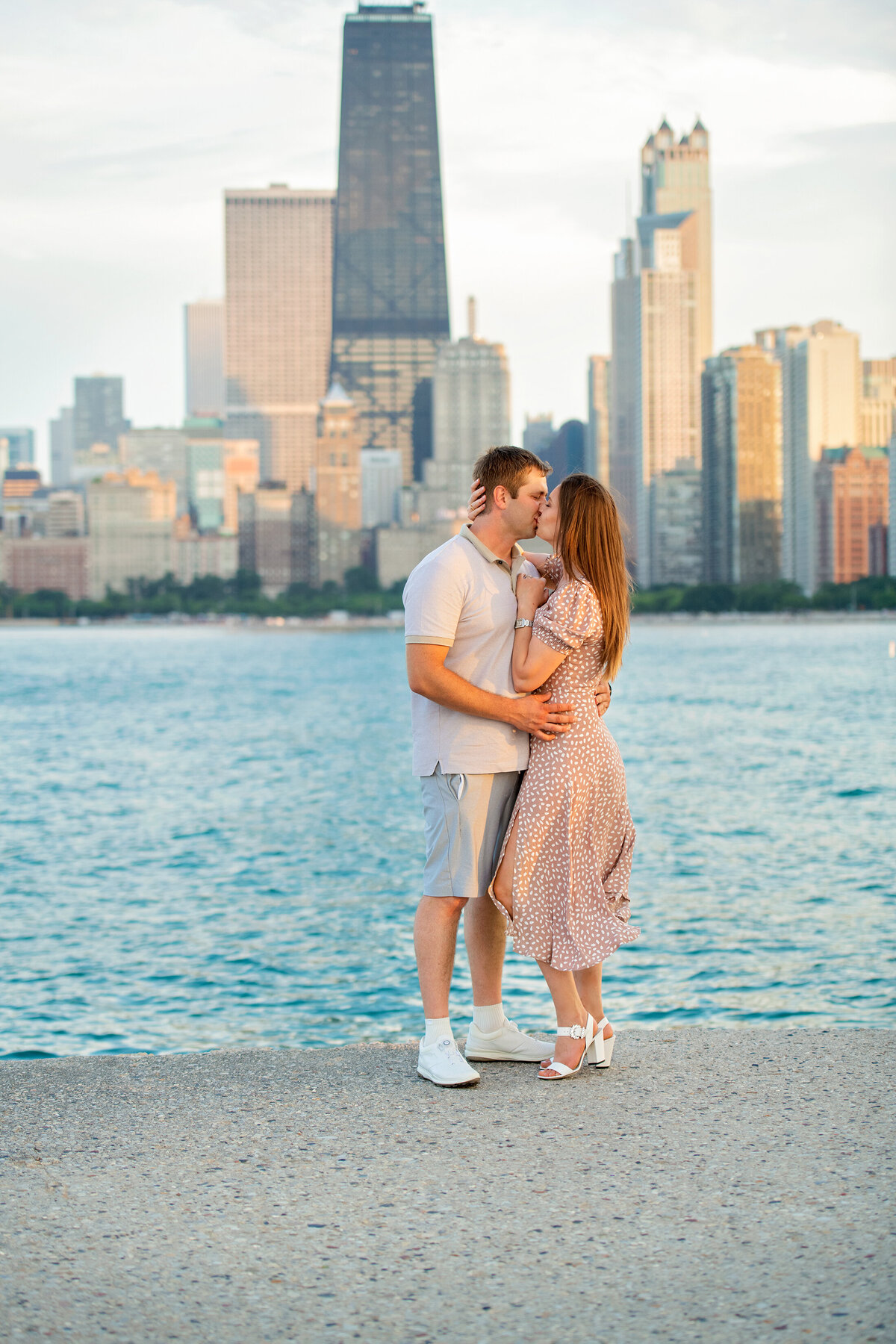 Engaged couple kissing  at North avenue beach by Lake Michigan