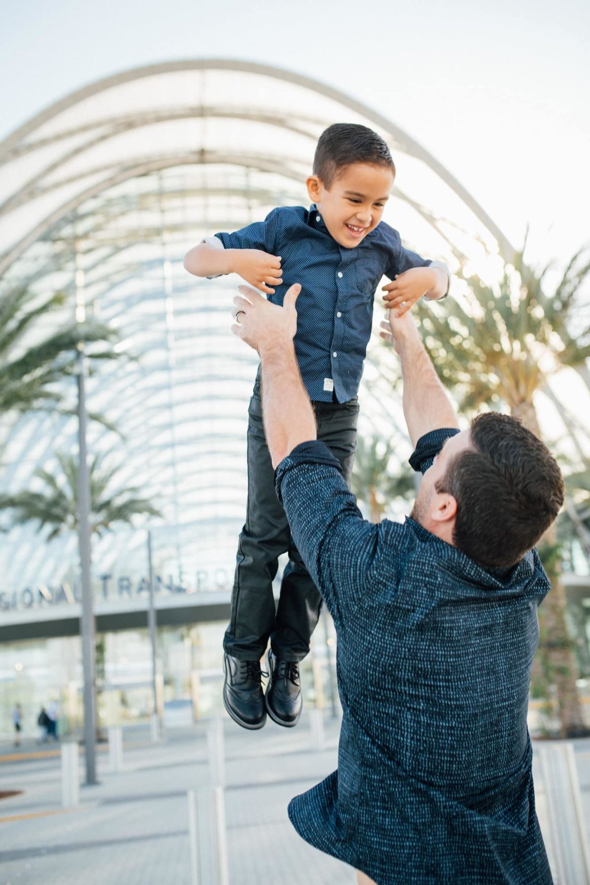 Dad tosses his young son in the air outside the ARTIC Train Station in Anaheim